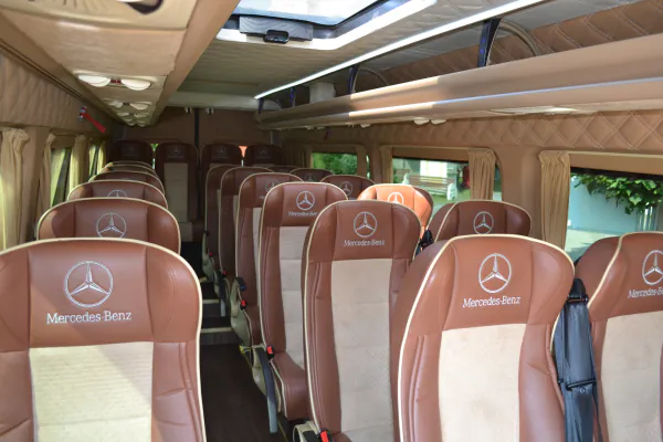 Rady kožených sedadiel s logom Mercedes-Benz v interiéri minibusu